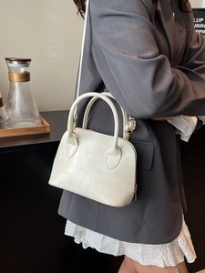 Chic cream white lace shell crossbody bag with top handles and a slender shoulder strap