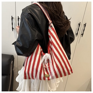 Detail of red and white striped canvas tote bag with lace bow and handmade tag
