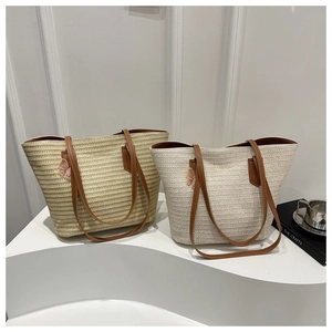 Detailed view of straw tote bags with leather straps and decorative 3D butterflies