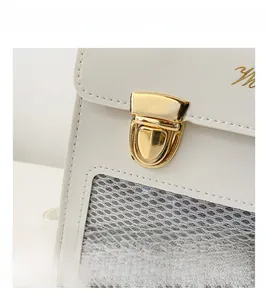 Detail of elegant ivory leather bag featuring gold rotary lock and fine embroidery
