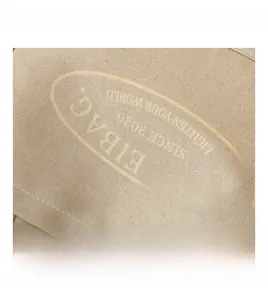 Close-up of beige canvas tote bag showing logo printing and metal rivet details