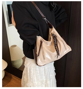 Detail of a large cream tote bag with contrast brown trim and vertical zipper