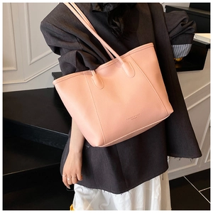 Pink faux leather tote bag with FASHION & BAGS lettering shown on model for daily commute