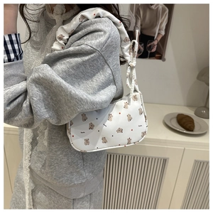 Detail of white canvas shoulder bag featuring cute koala prints and scrunchie strap
