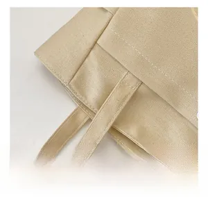 Close-up of reinforced stitching and durable canvas texture on a beige tote bag