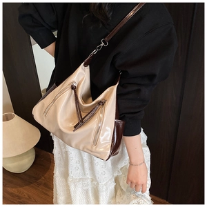 Detail of elegant two-tone cream and brown tote bag with stylish silver zipper accents