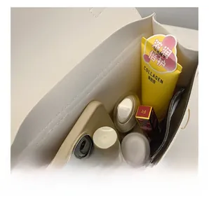 Spacious interior of white minimalist PU bag holding cosmetics and phone for daily use