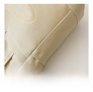 Detail showing high-density canvas texture and durable stitching of the tote bag