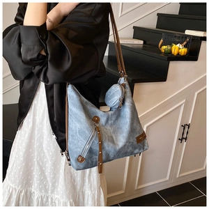 Nahaufnahme der hellblauen Vintage-Tasche mit braunen Lederriemen und Metallnieten