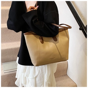 Close-up of elegant beige tote bag with brown handles and premium leather texture
