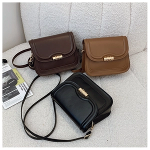 Detail of vintage leather crossbody bags with golden cylindrical locks in three colors