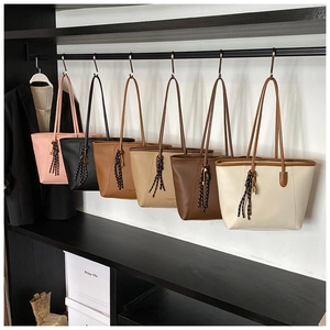 Row of leather tote bags in pink black brown and white on a metal display rack
