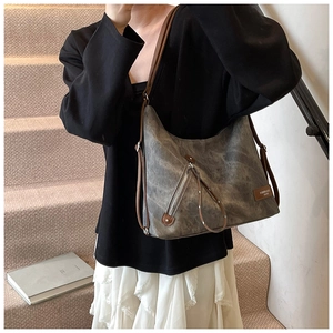 Detail der grauen Vintage-Canvas-Tasche mit braunem Lederriemen und Reißverschlüssen