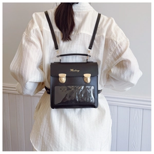 Detail of black PU leather ita bag with clear PVC window and gold metal buckle lock