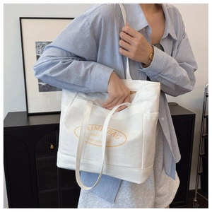 Canvas tote bag side view showing shoulder strap and functional side pocket detail