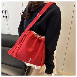 Détail macro du sac cabas rouge avec cordon vichy rouge et blanc et étiquette fashion