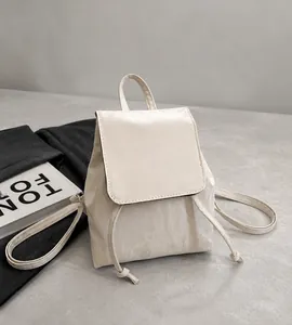 Detail of cream backpack showing natural wrinkled texture and elegant drawstring closure