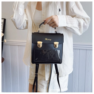 Detail showing the transparent PVC window and gold buckles on a black PU leather ita-bag