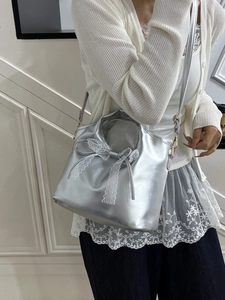 Silver metallic tote bag with white lace bow detail, stylish shoulder bag for women