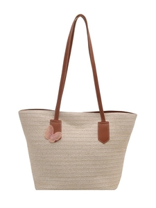 Large woven straw tote bag with brown leather handles and pink butterfly embroidery