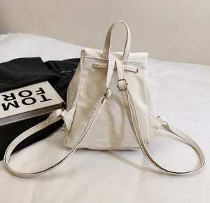 Detail back view of a white drawstring backpack with minimalist thin shoulder straps