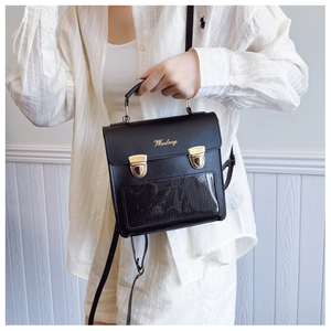 Detail of black retro PU leather bag with gold hardware and transparent pocket