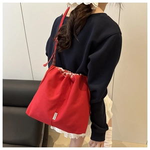 Détail du sac cabas en toile rouge avec bordure vichy et étiquette de mode élégante