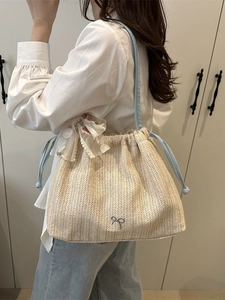 Große Stroh-Schultertasche mit blauem Kordelzug und floraler Schleife aus Spitze