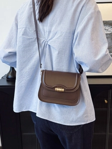 Borsa a tracolla classica in pelle marrone con fibbia dorata indossata dal modello