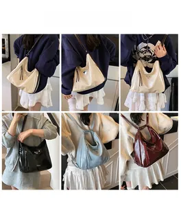 Vue détaillée de sacs hobo brillants en plusieurs couleurs avec logo triangulaire en métal