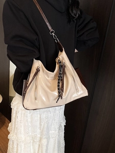 Chic beige large capacity tote bag with glossy finish and shoulder straps on a model