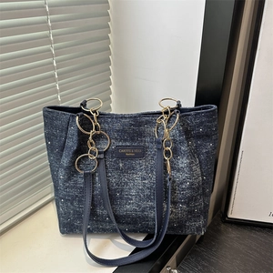 Grand sac cabas en denim bleu avec mouchetures argentées et chaînes dorées élégantes