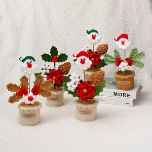 Handgemaakte gehaakte Kerstman en bloemen in pot voor feestelijke tafeldecoratie in huis