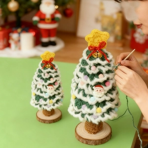 Dettaglio macro dell'albero di Natale in maglia verde e bianca con pompon di peluche colorati