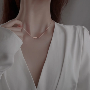 Minimalistische geometrische Roségold-Halskette mit Kristallpavé-Anhänger an einem Model
