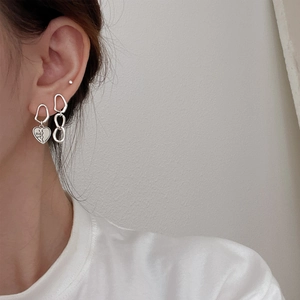 Close-up of S925 silver asymmetric heart and chain link earrings on model's ear