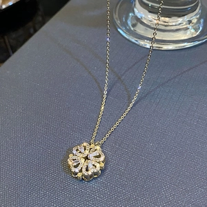 Macro shot of clover pendant with four heart-shaped crystals and gold plated chain
