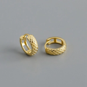 Macro view of gold S925 sterling silver huggie earrings with grid pattern texture