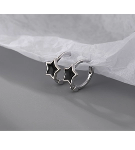 Detail of S925 silver star hoop earrings with black enamel inlay on grey surface