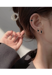 Detailed view of S925 silver heart ear cuff and black star studs on model's ear