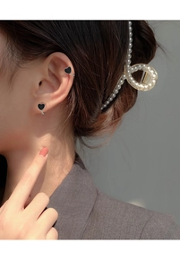 Close-up of s925 silver heart earring and ear cuff with black enamel on a female model