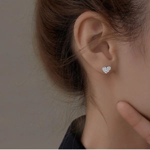 Boucles d'oreilles cœur en argent texturé au style minimaliste portées par un mannequin