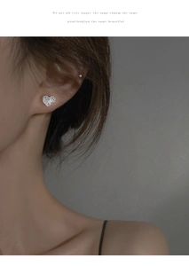 Détail d'une boucle d'oreille cœur de lave en argent sur modèle avec texture martelée