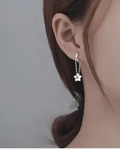 Close-up of S925 silver flower chain earrings featuring zircon studs on a model