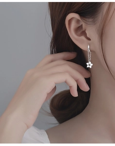 Detail of S925 silver flower earrings with tassel chains on a female model
