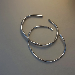Minimalist Mobius wave silver metal bangles set with a polished finish and fluid design