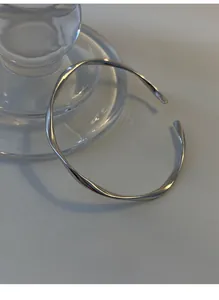 Detailed view of the Mobius silver bangle showing the elegant 180-degree twist design