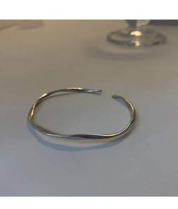 Macro detail of silver Mobius bracelet showing twisted wave design and mirror finish