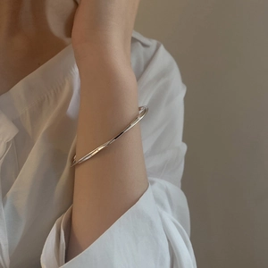 Minimalist silver Mobius bracelet with sleek twisted geometry and high-polish finish