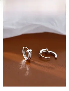 Detail of silver S925 geometric double-layer hoop earrings with signature T design
